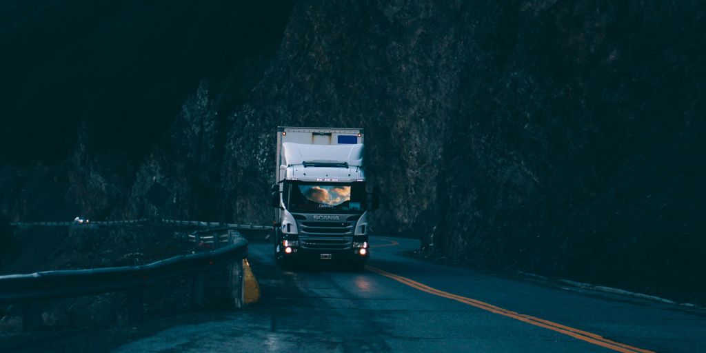 trailer truck passing on road near rail guard